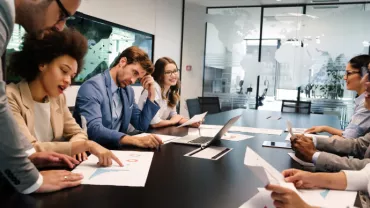 Réunion d'équipe autour d'une table avec des documents.