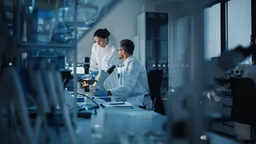 un homme et une femme dans un laboratoire sombre