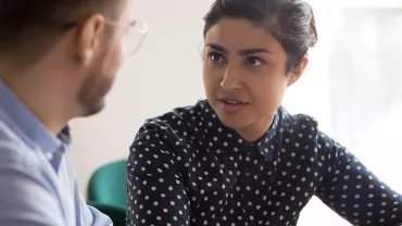 Deux personnes discutant dans un bureau.