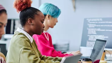 Personnes travaillant sur des ordinateurs portables dans un bureau moderne.