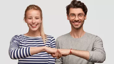 Deux personnes souriantes se tapent le poing.